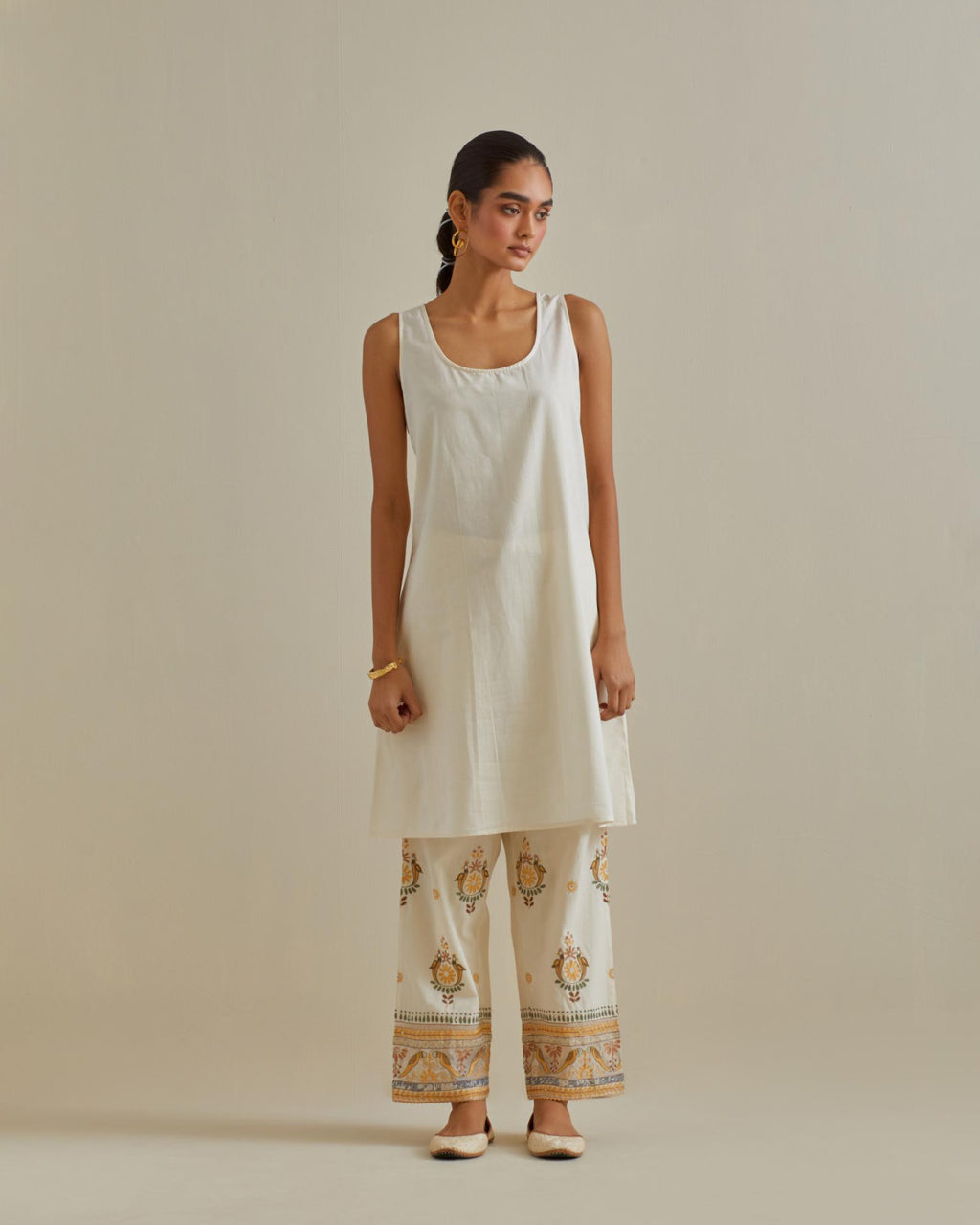 Yellow and off-white A-line cotton chanderi kurta set with all over patchwork, silk thread, mirror, tassels and sequin embroidery.