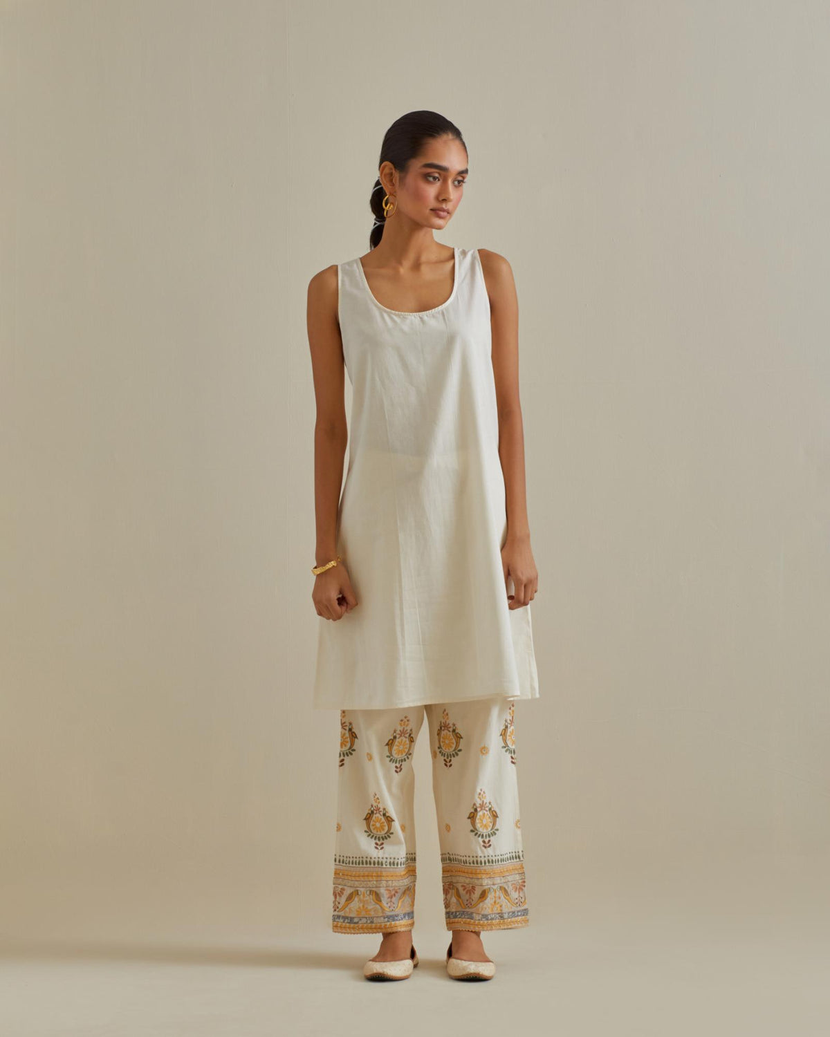 Yellow and off-white A-line cotton chanderi kurta set with all over patchwork, silk thread, mirror, tassels and sequin embroidery.
