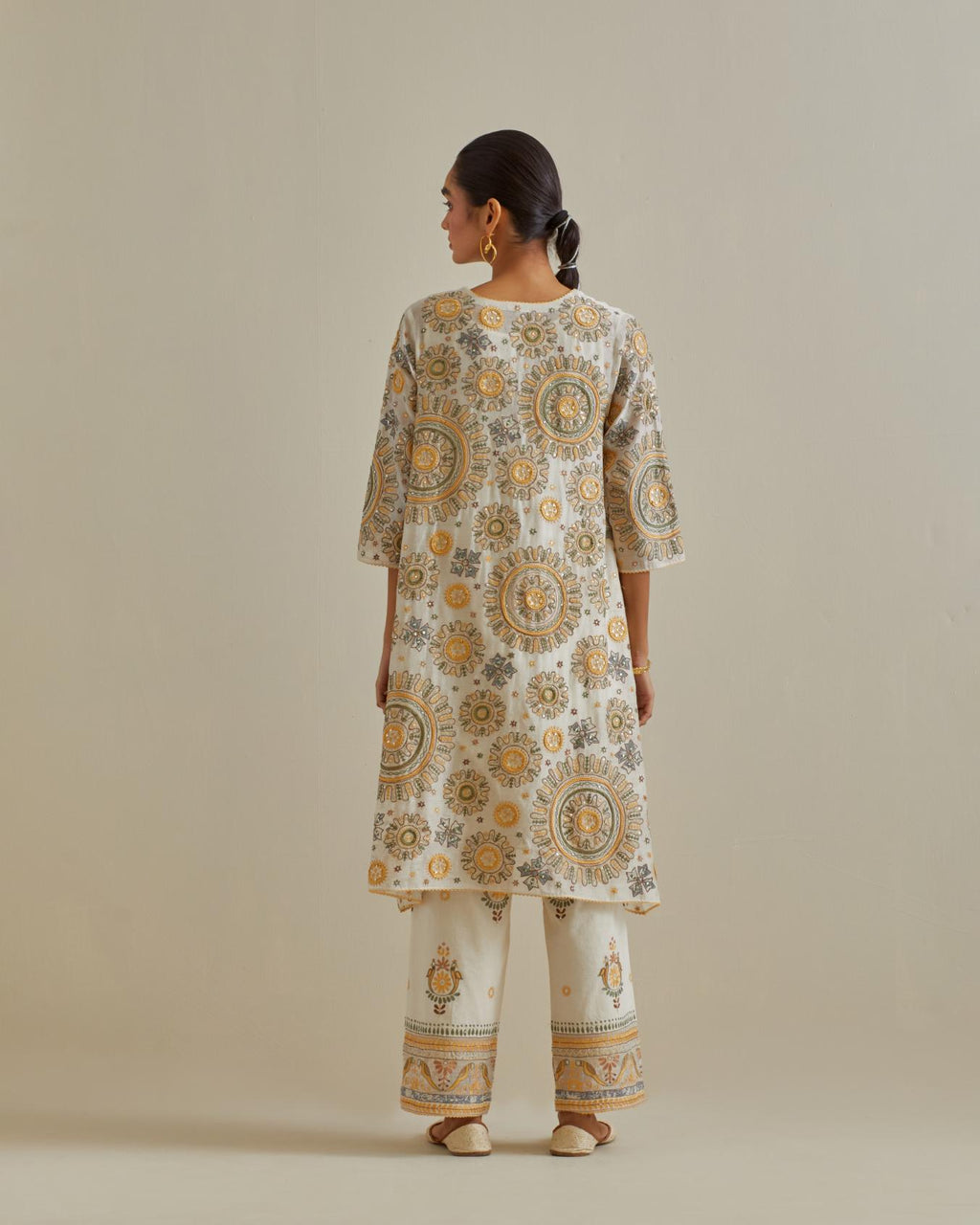 Yellow and off-white A-line cotton chanderi kurta set with all over patchwork, silk thread, mirror, tassels and sequin embroidery.