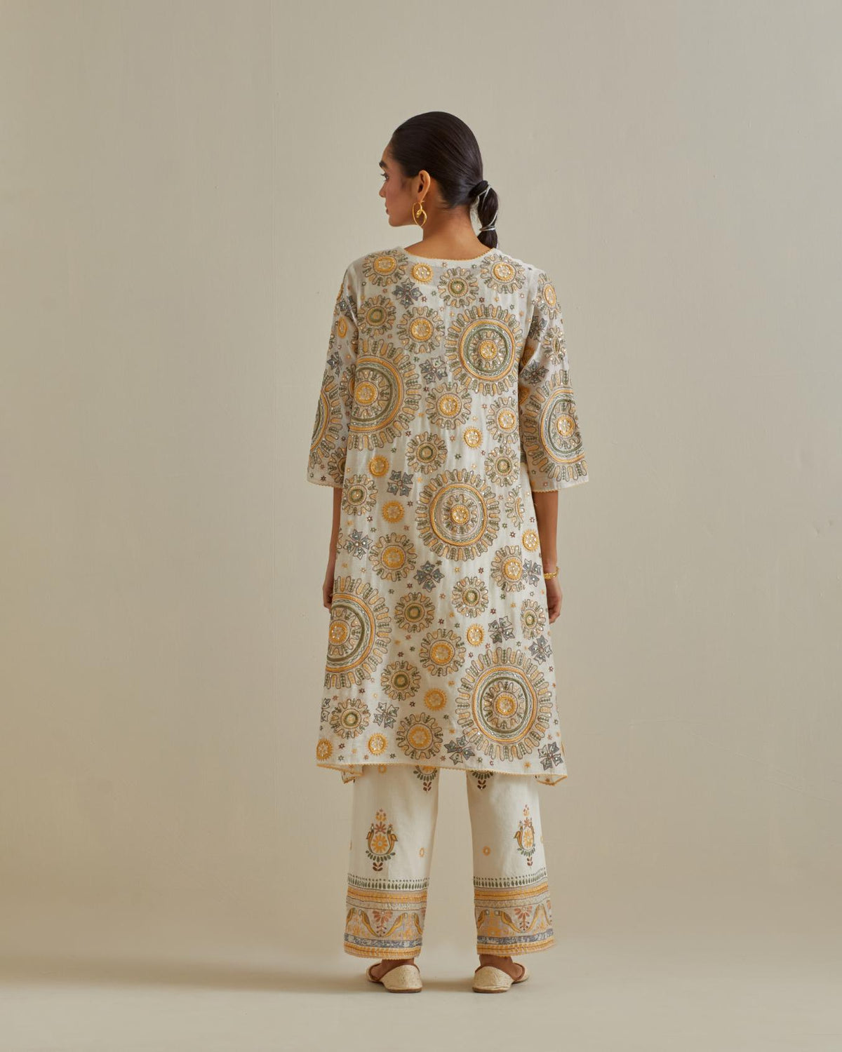 Yellow and off-white A-line cotton chanderi kurta set with all over patchwork, silk thread, mirror, tassels and sequin embroidery.