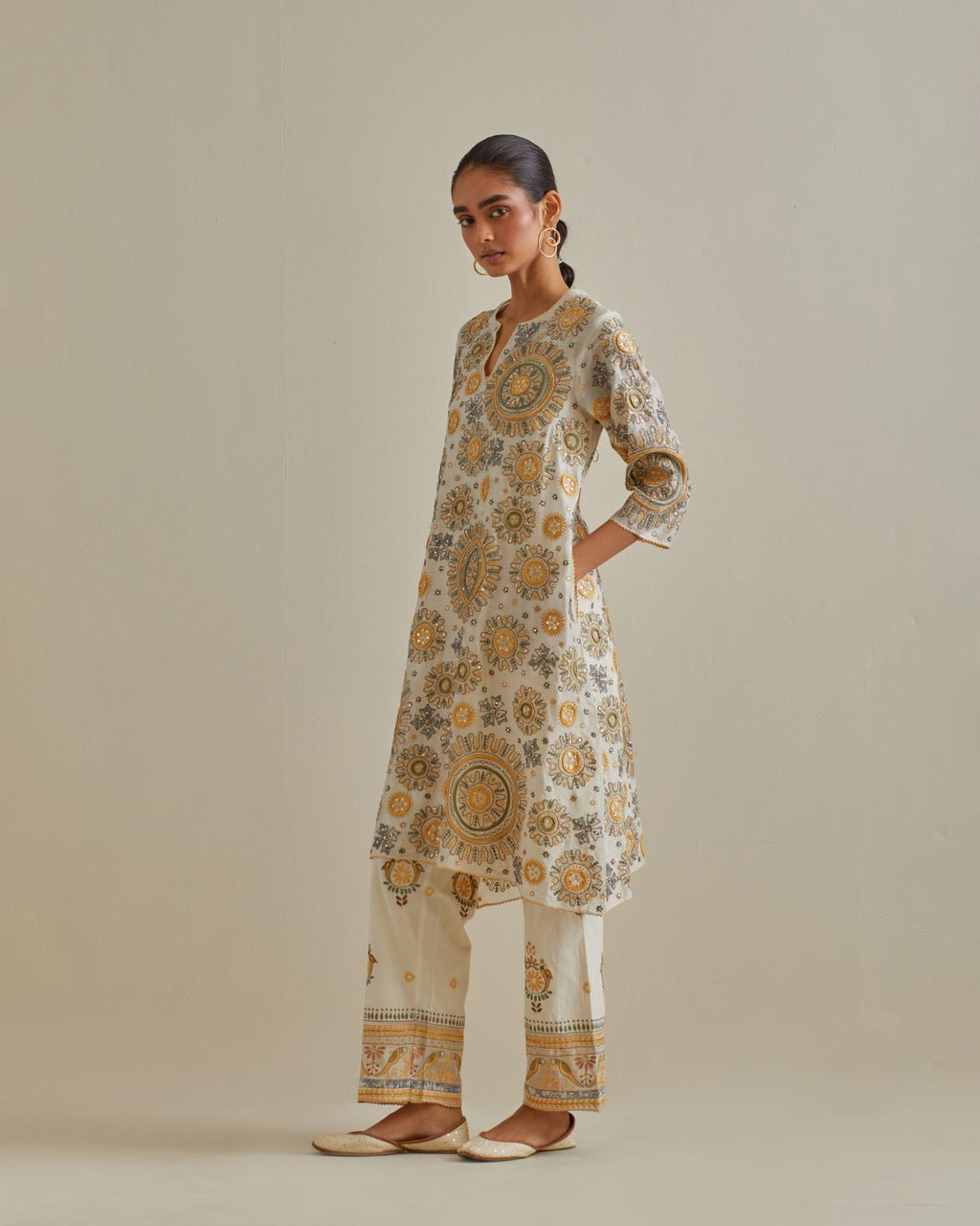 Yellow and off-white A-line cotton chanderi kurta set with all over patchwork, silk thread, mirror, tassels and sequin embroidery.