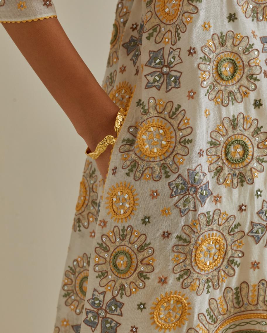 Yellow and off-white A-line cotton chanderi kurta set with all over patchwork, silk thread, mirror, tassels and sequin embroidery.