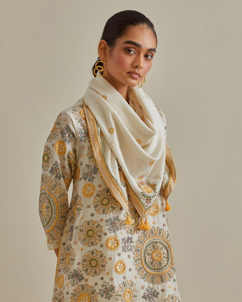 Yellow and off-white A-line silk kurta set with all over patchwork, silk thread, mirror, tassels and sequin embroidery.