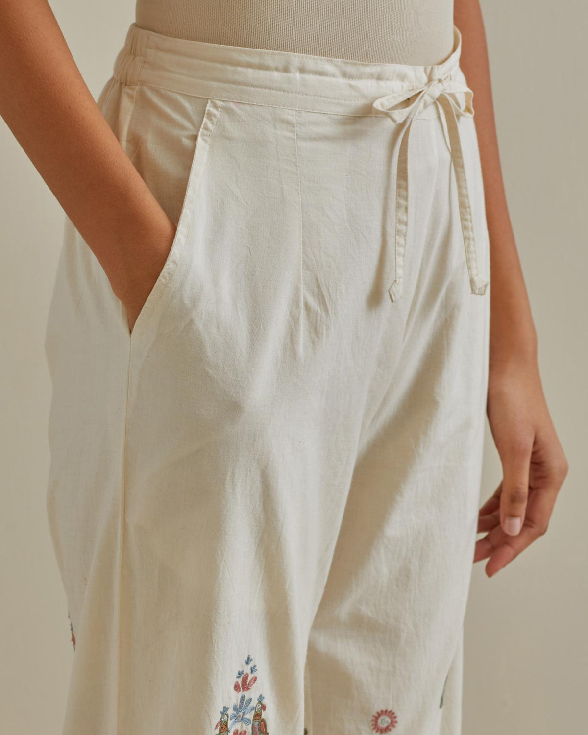Pink and off-white straight pants with all over multi color embroidery detailed with sequins.