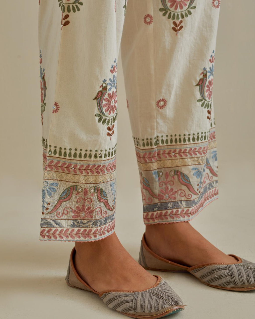 Pink and off-white straight pants with all over multi color embroidery detailed with sequins.