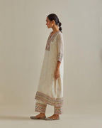 Pink and off-white cotton chanderi straight kurta set with yoke with patchwork and silk thread embroidery highlighted with mirror, sequins, tassels and braids.