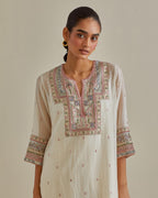 Pink and off-white cotton chanderi straight kurta set with yoke with patchwork and silk thread embroidery highlighted with mirror, sequins, tassels and braids.