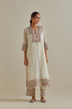 Pink and off-white cotton chanderi straight kurta set with yoke with patchwork and silk thread embroidery highlighted with mirror, sequins, tassels and braids.