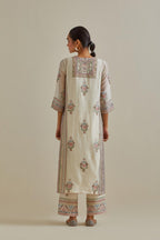 Pink and off-white cotton chanderi straight kurta set with yoke and side panels. It has allover patchwork and silk thread embroidery, highlighted with mirror, sequins, tassels and braids.