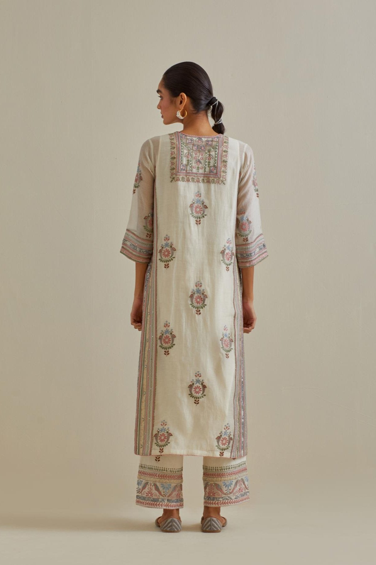 Pink and off-white cotton chanderi straight kurta set with yoke and side panels. It has allover patchwork and silk thread embroidery, highlighted with mirror, sequins, tassels and braids.