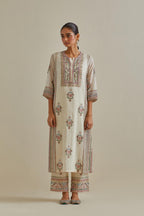Pink and off-white cotton chanderi straight kurta set with yoke and side panels. It has allover patchwork and silk thread embroidery, highlighted with mirror, sequins, tassels and braids.
