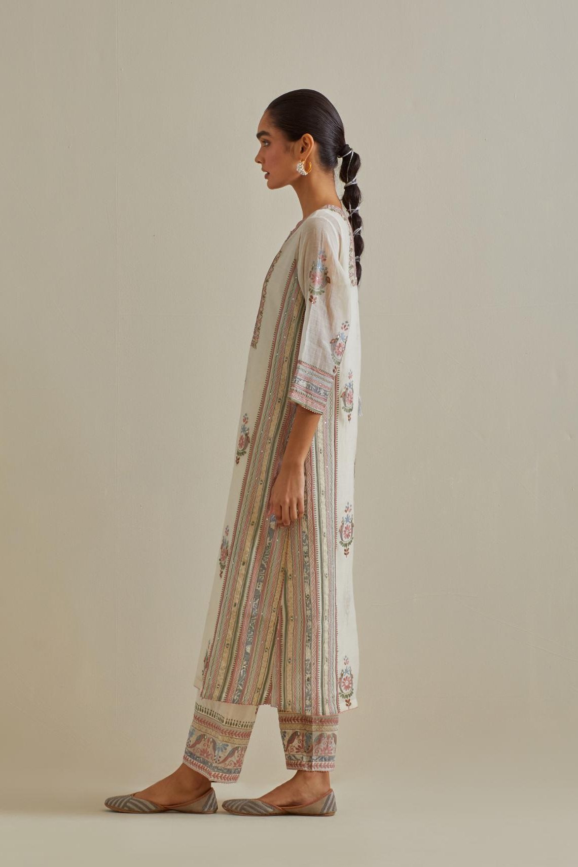 Pink and off-white cotton chanderi straight kurta set with yoke and side panels. It has allover patchwork and silk thread embroidery, highlighted with mirror, sequins, tassels and braids.