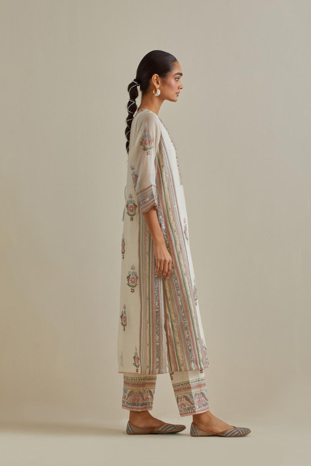 Pink and off-white cotton chanderi straight kurta set with yoke and side panels. It has allover patchwork and silk thread embroidery, highlighted with mirror, sequins, tassels and braids.