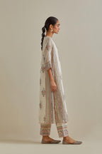 Pink and off-white cotton chanderi straight kurta set with yoke and side panels. It has allover patchwork and silk thread embroidery, highlighted with mirror, sequins, tassels and braids.