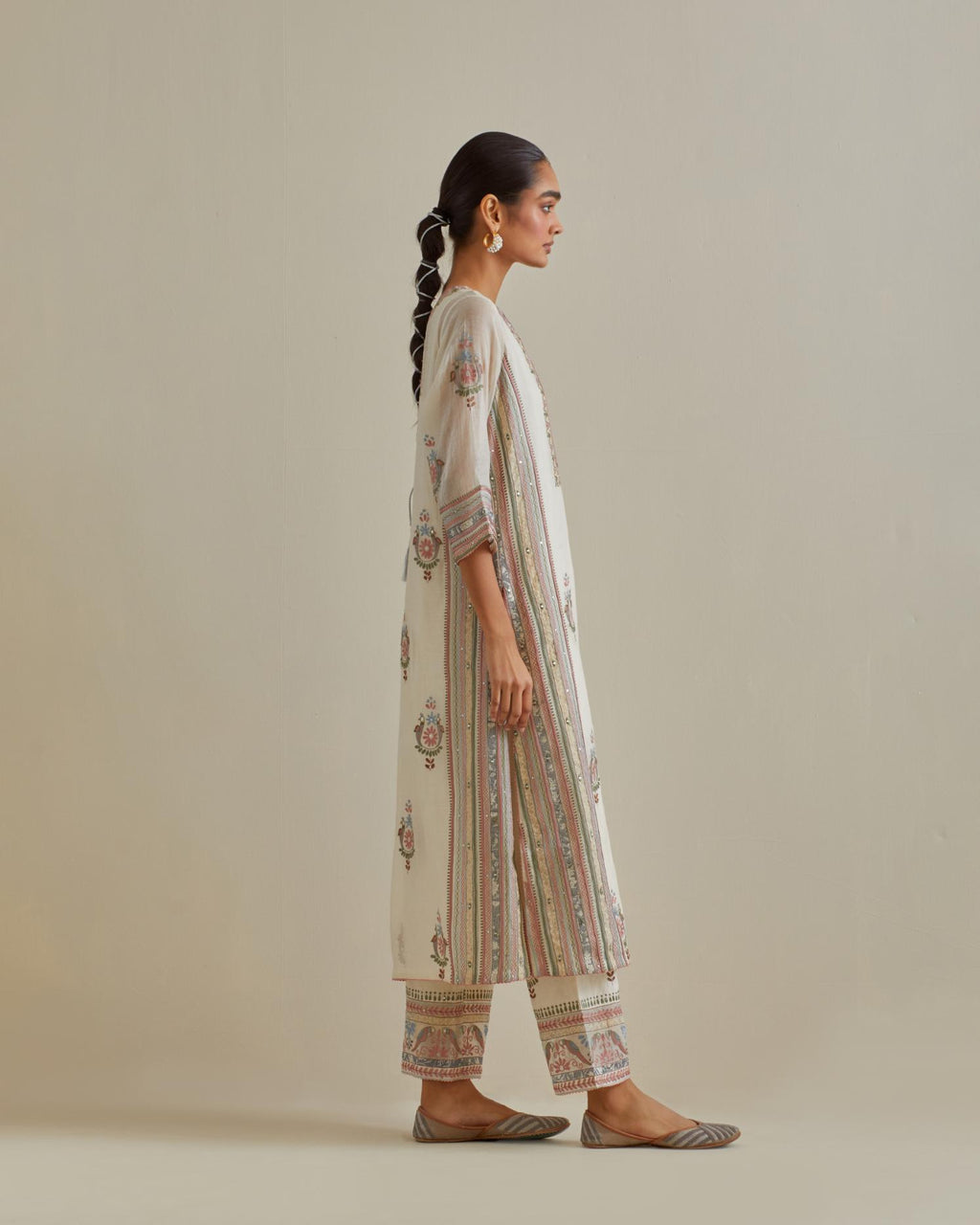 Pink and off-white cotton chanderi straight kurta set with yoke and side panels. It has allover patchwork and silk thread embroidery, highlighted with mirror, sequins, tassels and braids.