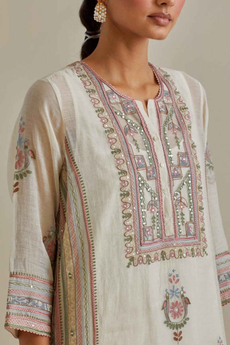 Pink and off-white cotton chanderi straight kurta set with yoke and side panels. It has allover patchwork and silk thread embroidery, highlighted with mirror, sequins, tassels and braids.