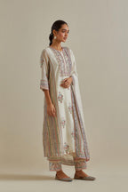 Pink and off-white cotton chanderi straight kurta set with yoke and side panels. It has allover patchwork and silk thread embroidery, highlighted with mirror, sequins, tassels and braids.