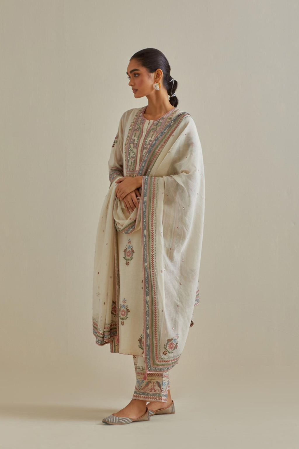 Pink and off-white cotton chanderi straight kurta set with yoke and side panels. It has allover patchwork and silk thread embroidery, highlighted with mirror, sequins, tassels and braids.