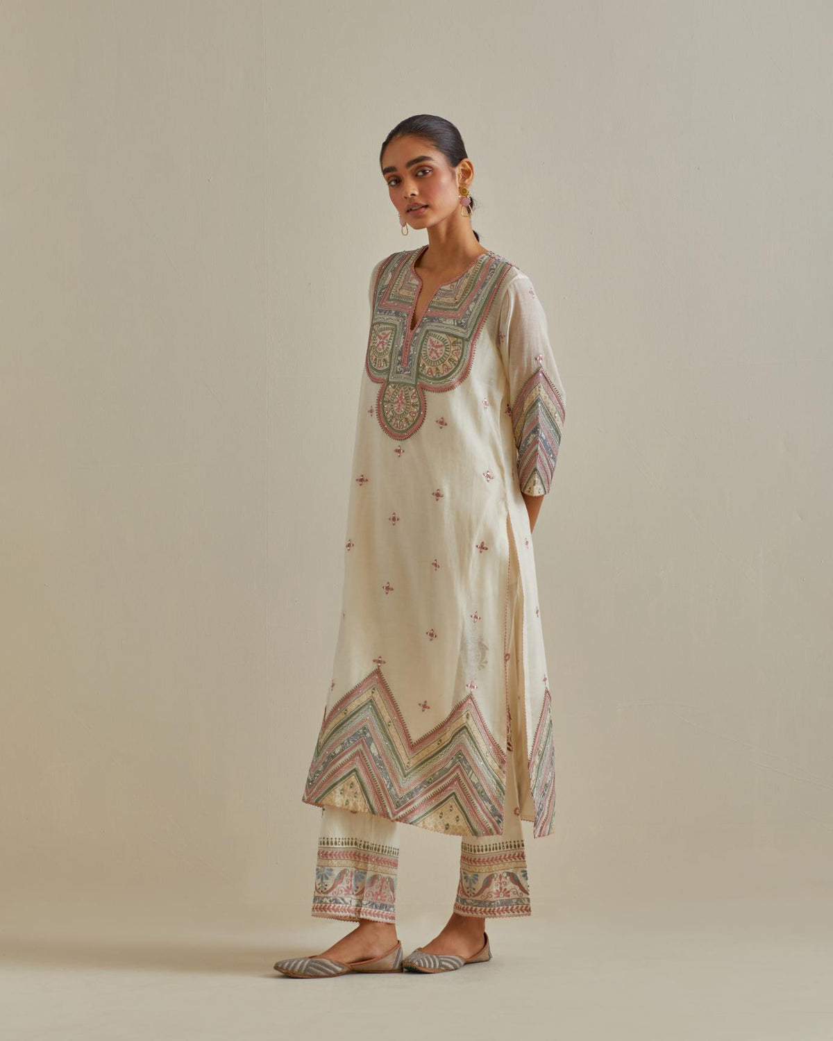 Pink and off-white cotton chanderi straight kurta set with patchwork and thread embroidery highlighted with mirrors, sequins, tassels and braids.