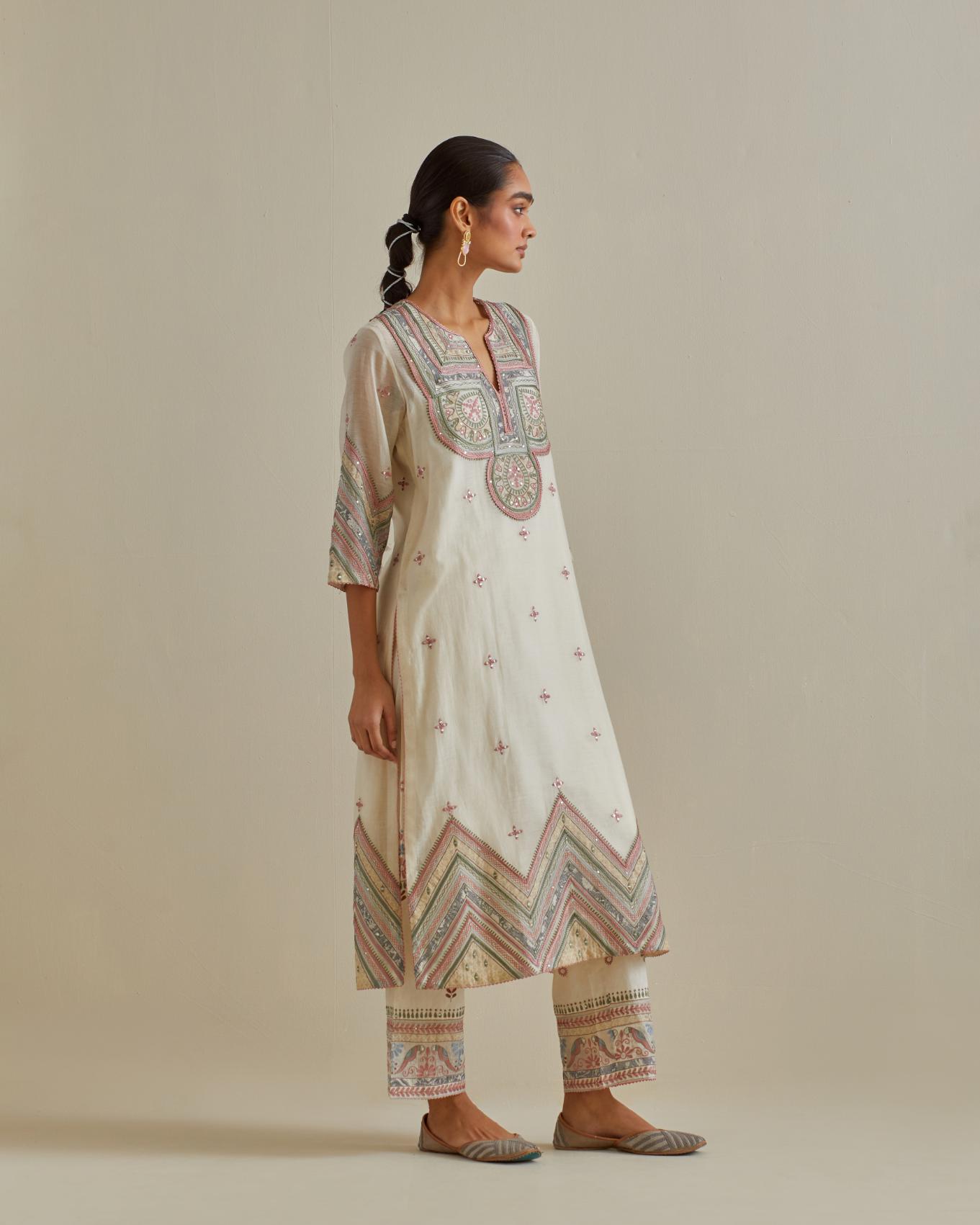 Pink and off-white cotton chanderi straight kurta set with patchwork and thread embroidery highlighted with mirrors, sequins, tassels and braids.