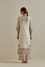 Pink and off-white cotton chanderi straight kurta set with yoke with patchwork and silk thread embroidery highlighted with mirror, sequins, tassels and braids.