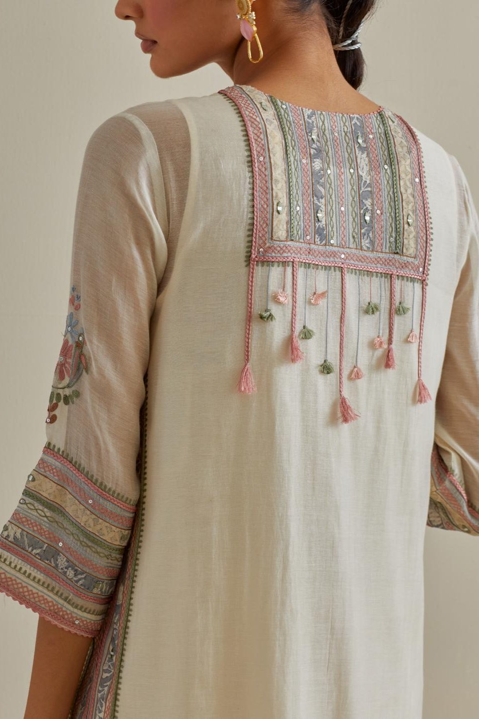 Pink and off-white cotton chanderi straight kurta set with yoke with patchwork and silk thread embroidery highlighted with mirror, sequins, tassels and braids.