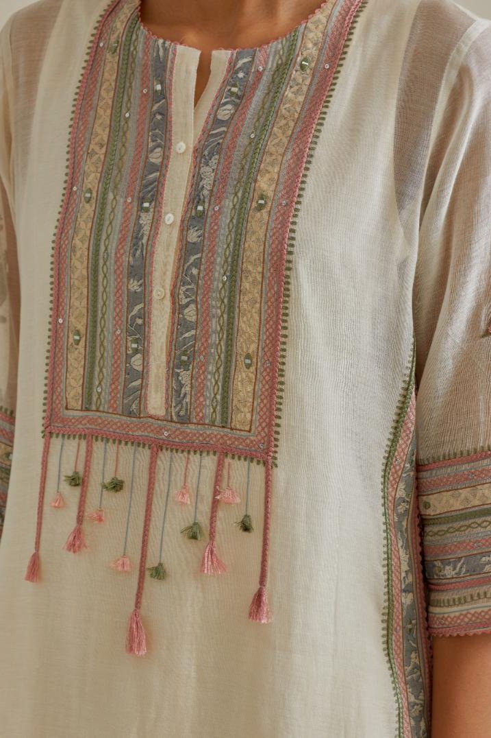 Pink and off-white cotton chanderi straight kurta set with yoke with patchwork and silk thread embroidery highlighted with mirror, sequins, tassels and braids.