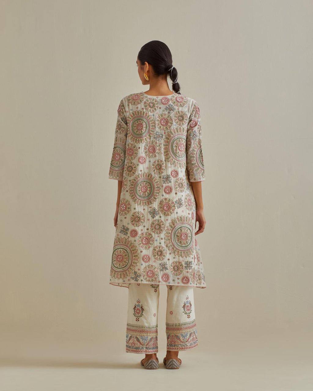 Pink and off-white A-line silk kurta set with all over patchwork, silk thread, mirror, tassels and sequin embroidery.