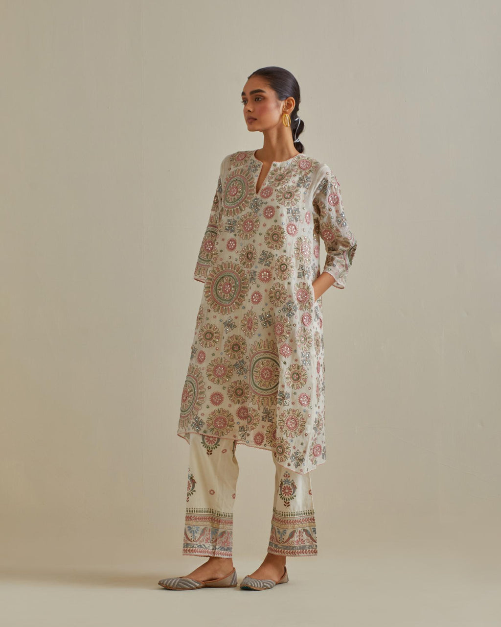 Pink and off-white A-line silk kurta set with all over patchwork, silk thread, mirror, tassels and sequin embroidery.