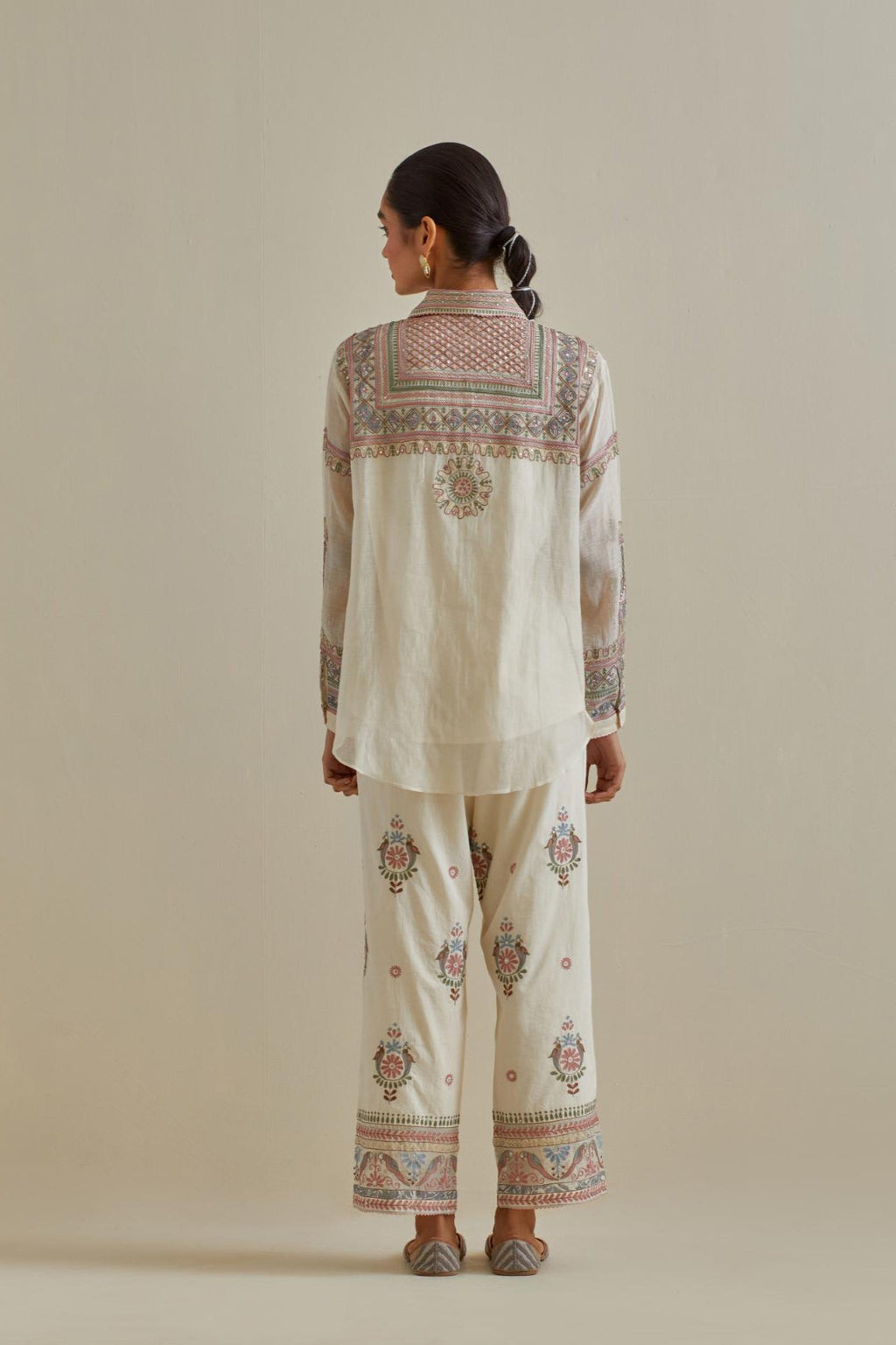 Pink and off-white cotton chanderi embroidered shirt with full sleeves, paired with off white cotton straight pants with all over multi color embroidery detailed with sequins.