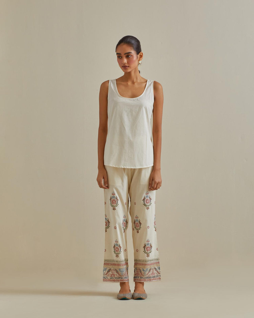 Pink and off-white cotton chanderi embroidered short top with 3/4th sleeves, paired with off white cotton straight pants with all over multi color embroidery detailed with sequins.