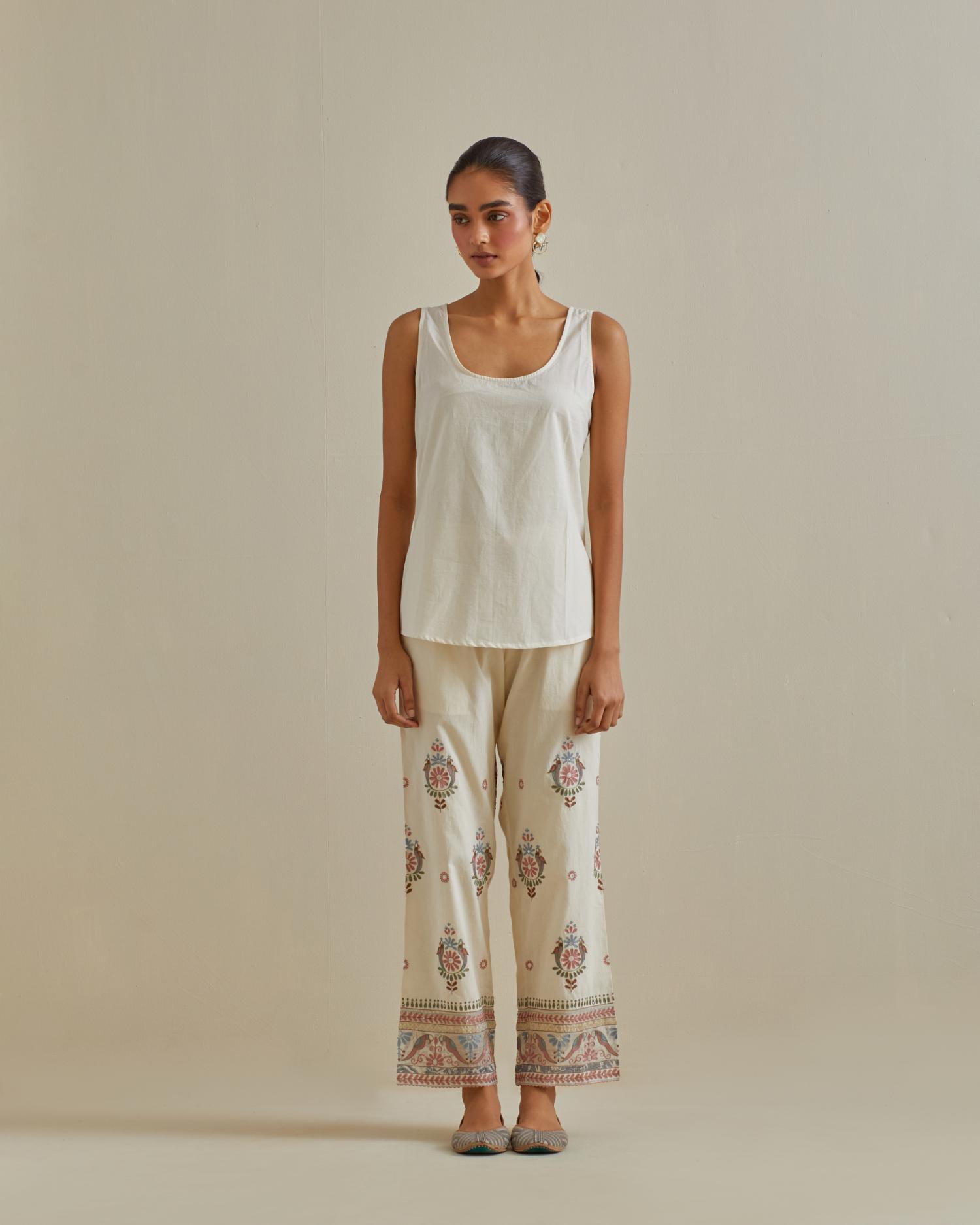 Pink and off-white cotton chanderi embroidered short top with 3/4th sleeves, paired with off white cotton straight pants with all over multi color embroidery detailed with sequins.