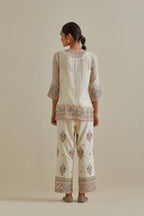 Pink and off-white cotton chanderi embroidered short top with 3/4th sleeves, paired with off white cotton straight pants with all over multi color embroidery detailed with sequins.