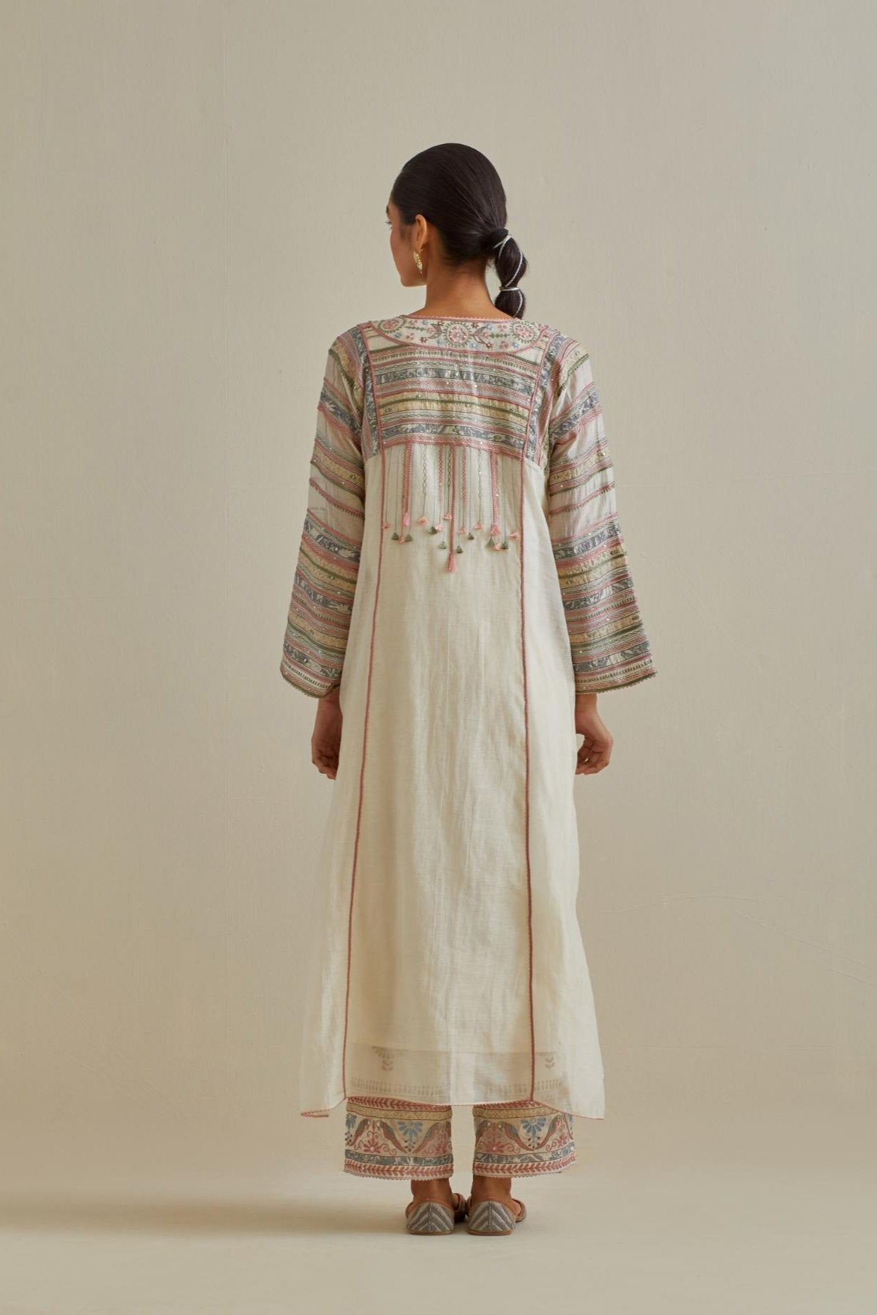 Pink and off-white cotton chanderi easy fit long kaftan detailed with patch, silk thread, mirror & sequins work, paired with off white cotton straight pants with all over multi color embroidery detailed with sequins.