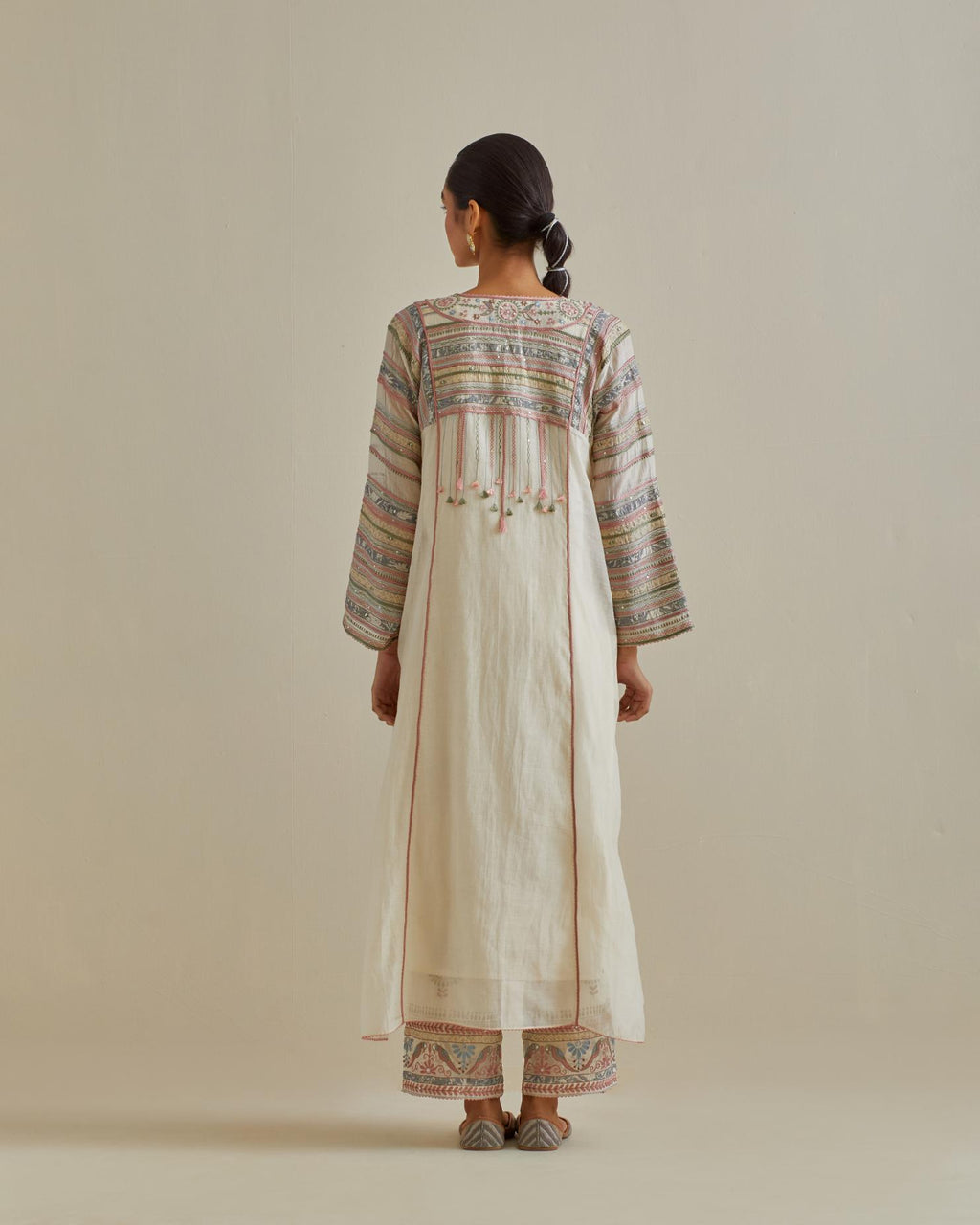 Pink and off-white cotton chanderi easy fit long kaftan detailed with patch, silk thread, mirror & sequins work, paired with off white cotton straight pants with all over multi color embroidery detailed with sequins.