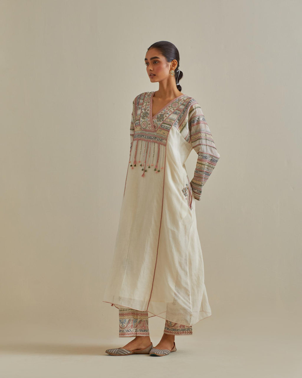 Pink and off-white cotton chanderi easy fit long kaftan detailed with patch, silk thread, mirror & sequins work, paired with off white cotton straight pants with all over multi color embroidery detailed with sequins.