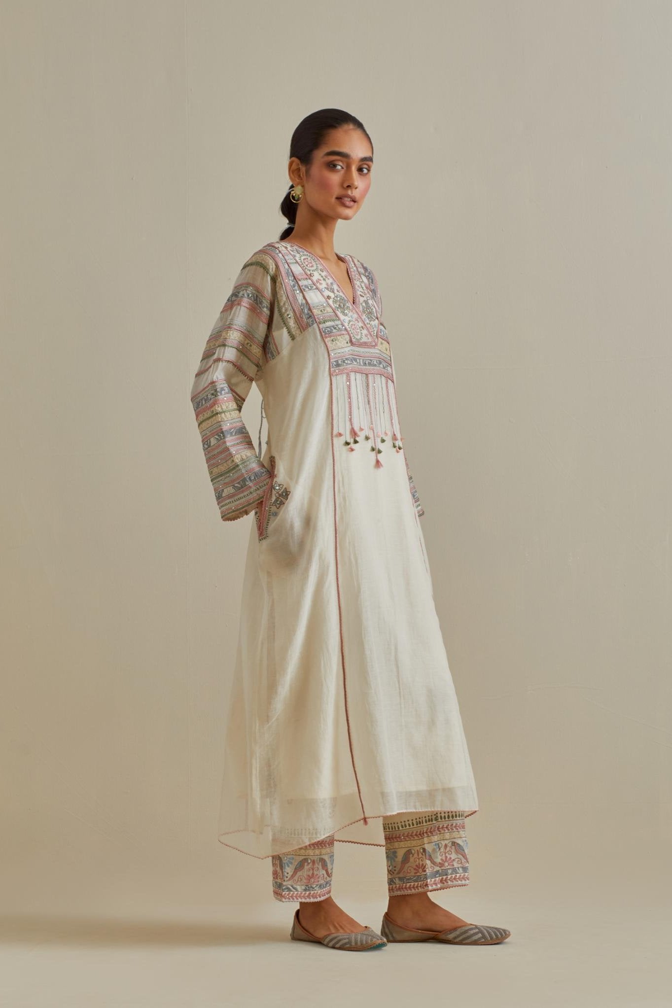 Pink and off-white cotton chanderi easy fit long kaftan detailed with patch, silk thread, mirror & sequins work, paired with off white cotton straight pants with all over multi color embroidery detailed with sequins.