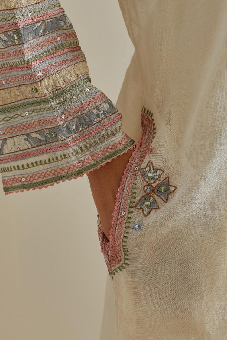 Pink and off-white cotton chanderi easy fit long kaftan detailed with patch, silk thread, mirror & sequins work, paired with off white cotton straight pants with all over multi color embroidery detailed with sequins.