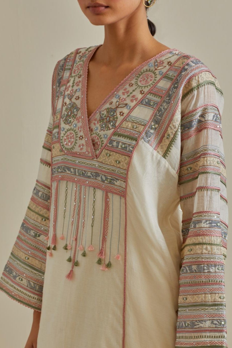 Pink and off-white cotton chanderi easy fit long kaftan detailed with patch, silk thread, mirror & sequins work, paired with off white cotton straight pants with all over multi color embroidery detailed with sequins.