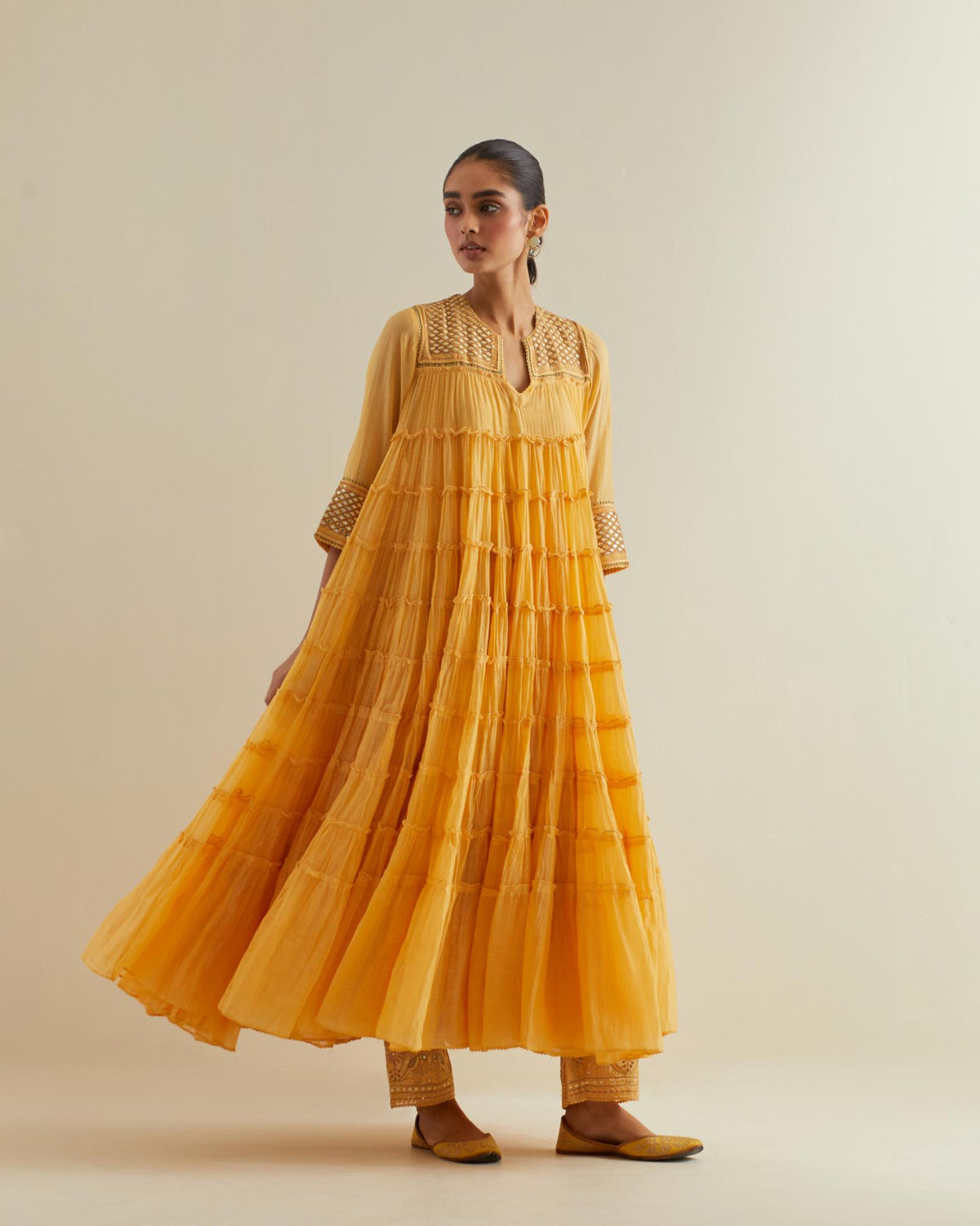 Yellow cotton chanderi multi-tiered kurta dress set with 3/4 sleeves, highlighted with mirror work.