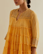 Yellow cotton chanderi multi-tiered kurta dress set with 3/4 sleeves, highlighted with mirror work.
