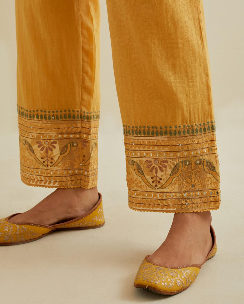 Yellow straight pants with all over multi color embroidery detailed with sequins.