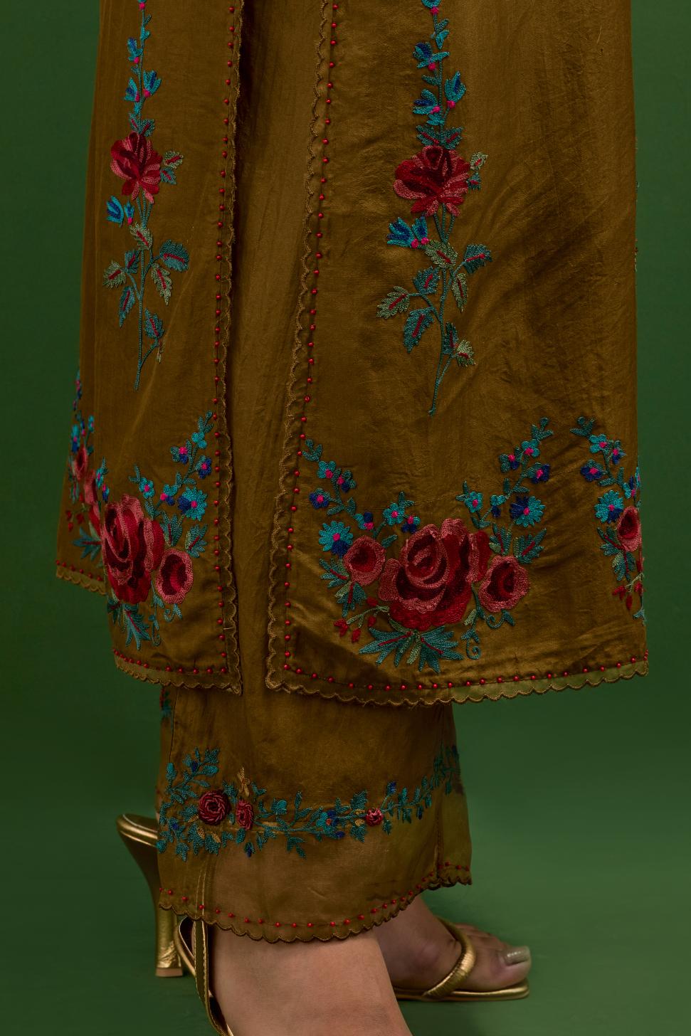 Golden olive silk straight kurta set with all-over rose embroidery and scalloped organza detail at the edges.