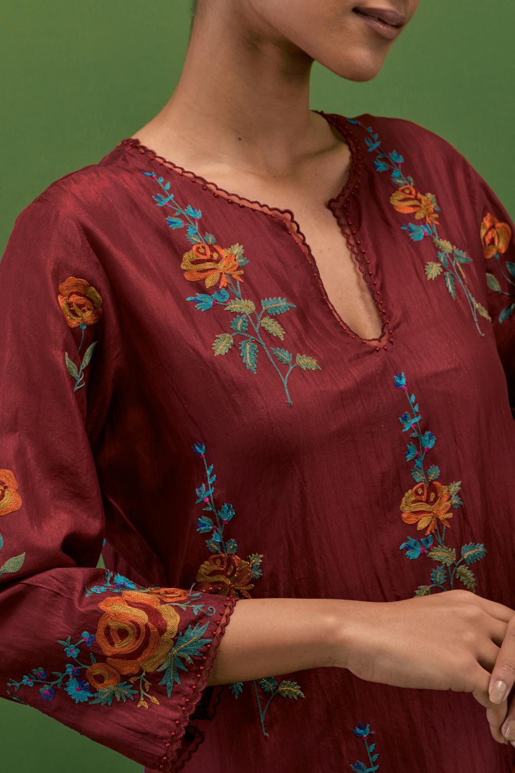 Rosewood silk straight kurta set with all-over rose embroidery and scalloped organza detail at the edges.