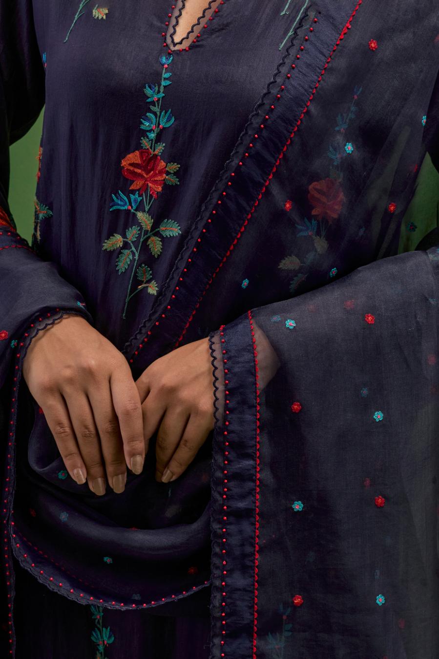 Midnight blue silk straight kurta set with all-over rose embroidery and scalloped organza detail at the edges.