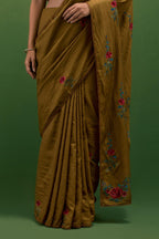 Golden olive silk saree with all-over thread embroidered roses and scalloped organza with delicate bead detail at the edges, paired with golden olive silk blouse with all-over pin tucks, highlighted with bead work.