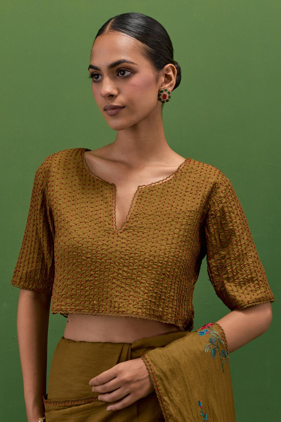 Golden olive silk blouse with all-over pin tucks, highlighted with bead work.