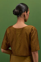 Golden olive silk saree with all-over thread embroidered roses and scalloped organza with delicate bead detail at the edges, paired with golden olive silk blouse with all-over pin tucks, highlighted with bead work.