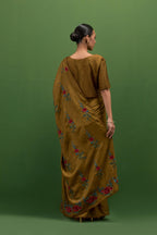 Golden olive silk saree with all-over thread embroidered roses and scalloped organza with delicate bead detail at the edges, paired with golden olive silk blouse with all-over pin tucks, highlighted with bead work.