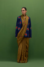 Golden olive silk saree with all-over thread embroidered roses and scalloped organza with delicate bead detail at the edges, paired with golden olive silk blouse with all-over pin tucks, highlighted with bead work.
